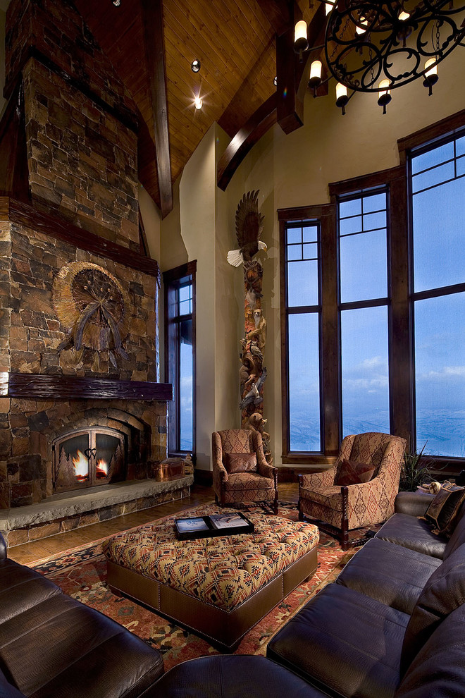 Rustic living room in Salt Lake City with beige walls, dark hardwood flooring, a standard fireplace and a stone fireplace surround.
