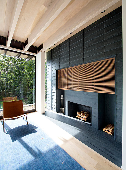 Inspiration pour un salon minimaliste avec parquet clair, une cheminée standard et un manteau de cheminée en pierre.
