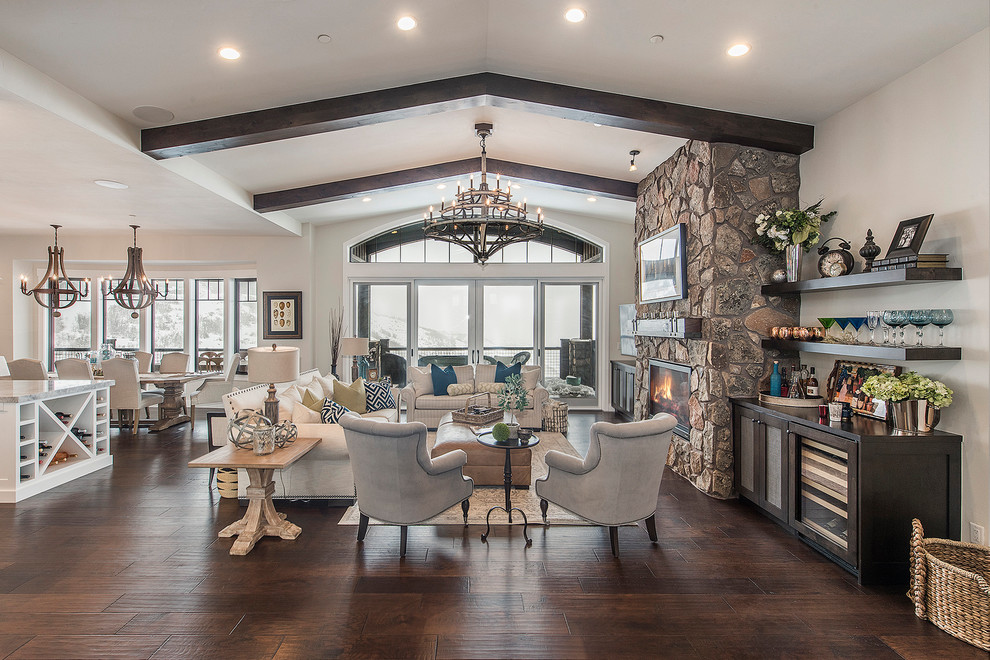 Photo of a large rustic formal open plan living room in Salt Lake City with white walls, dark hardwood flooring, a ribbon fireplace, a stone fireplace surround, brown floors, no tv and feature lighting.