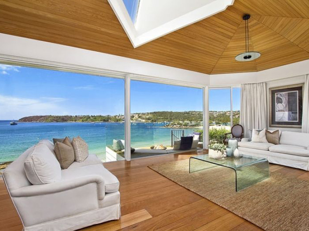 Fernseherloses Wohnzimmer ohne Kamin mit weißer Wandfarbe und braunem Holzboden in Sydney