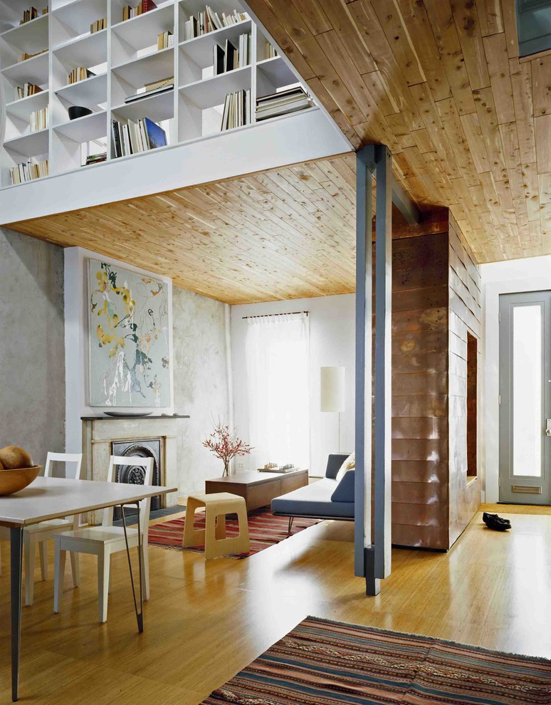На фото: парадная гостиная комната среднего размера в современном стиле с серыми стенами, светлым паркетным полом, двусторонним камином и фасадом камина из камня без телевизора с