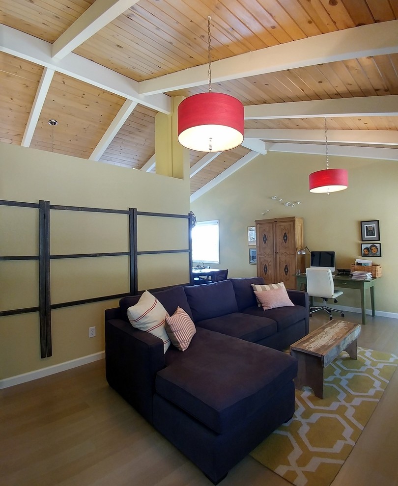 Foto di un soggiorno minimal di medie dimensioni e aperto con pareti gialle, pavimento in legno massello medio, camino classico, cornice del camino in mattoni e TV autoportante