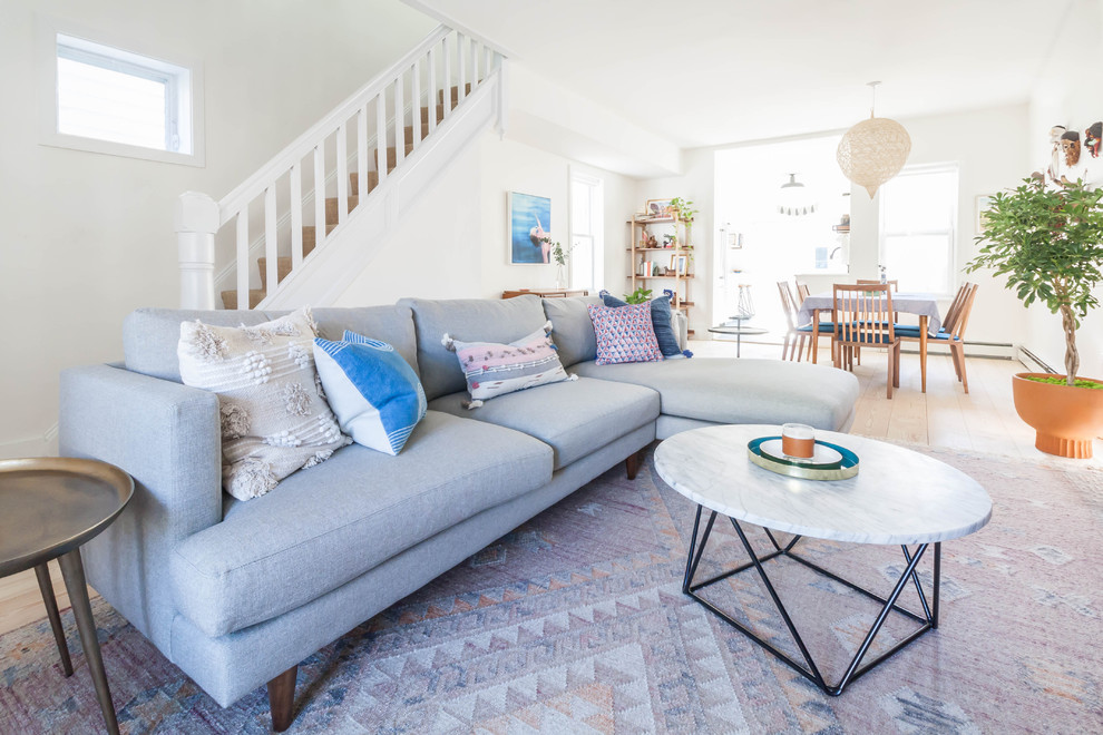 Mid-sized danish open concept light wood floor living room photo in New York with white walls and a wall-mounted tv