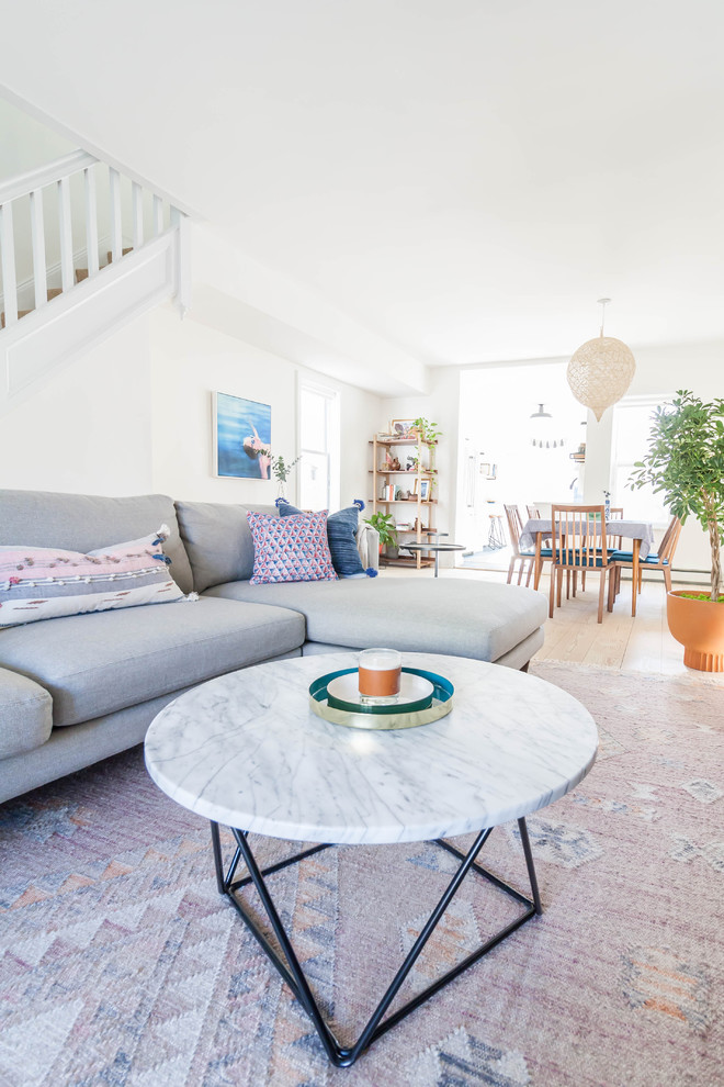 Immagine di un soggiorno scandinavo di medie dimensioni e aperto con pareti bianche, parquet chiaro e TV a parete