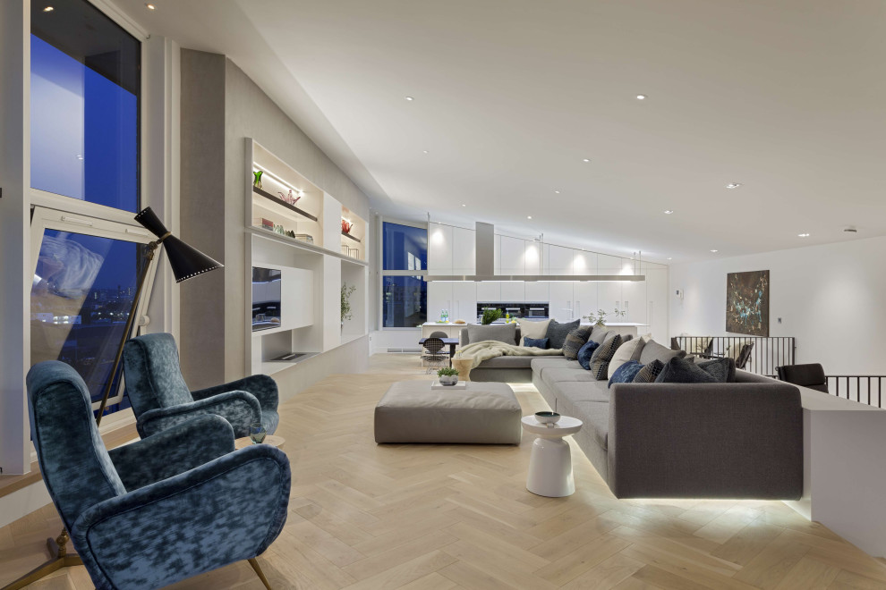Immagine di un grande soggiorno minimal stile loft con sala formale, pareti bianche, parquet chiaro, parete attrezzata, pavimento marrone e soffitto a volta