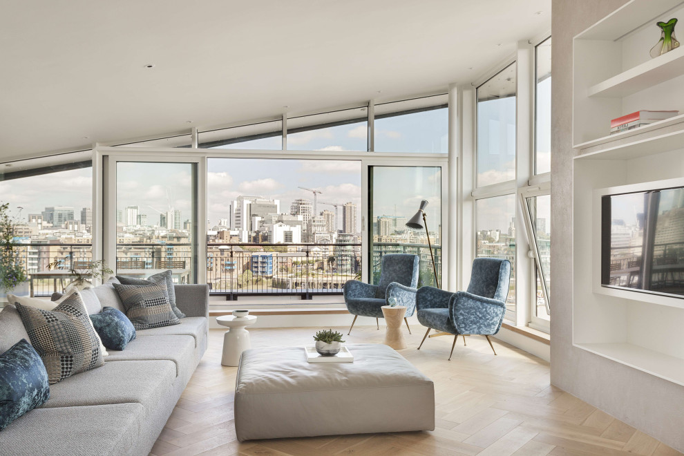 Large contemporary formal mezzanine living room in London with white walls, light hardwood flooring, a built-in media unit, brown floors and a vaulted ceiling.