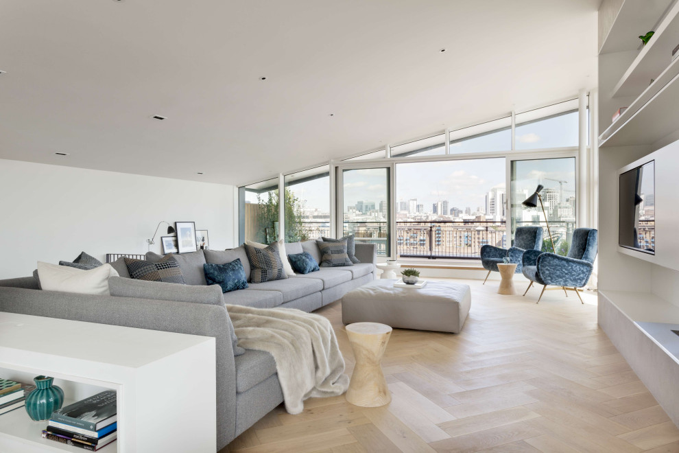 Immagine di un grande soggiorno design stile loft con sala formale, pareti bianche, parquet chiaro, parete attrezzata, pavimento marrone e soffitto a volta