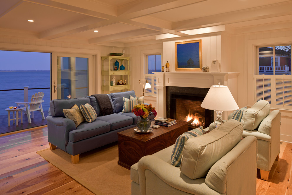 Großes, Offenes Maritimes Wohnzimmer mit weißer Wandfarbe, braunem Holzboden, Kamin und Kaminumrandung aus Stein in Boston