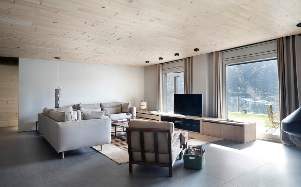 Ejemplo de salón para visitas abierto escandinavo de tamaño medio sin chimenea con suelo de baldosas de cerámica, televisor independiente y paredes grises