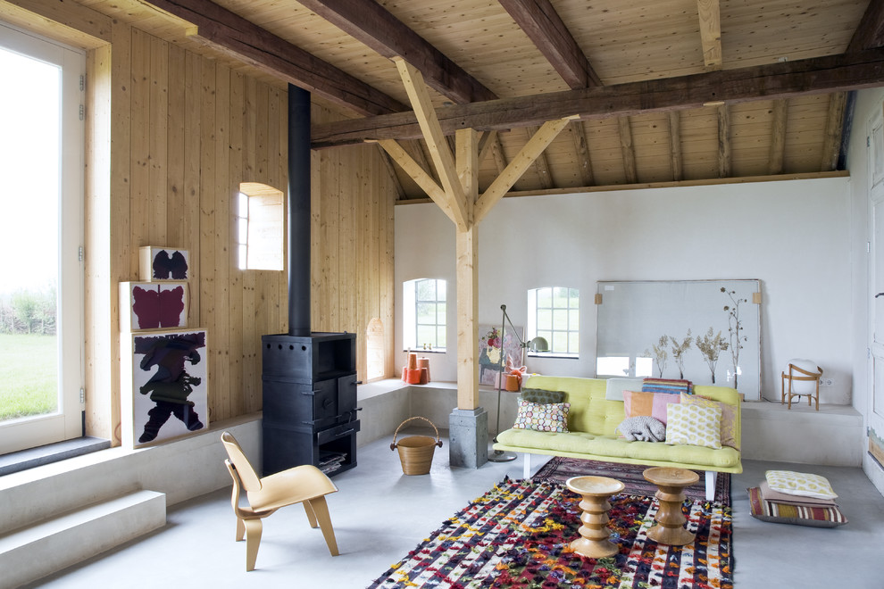 Design ideas for a medium sized scandi formal enclosed living room in Barcelona with white walls, concrete flooring, a wood burning stove, a metal fireplace surround and no tv.