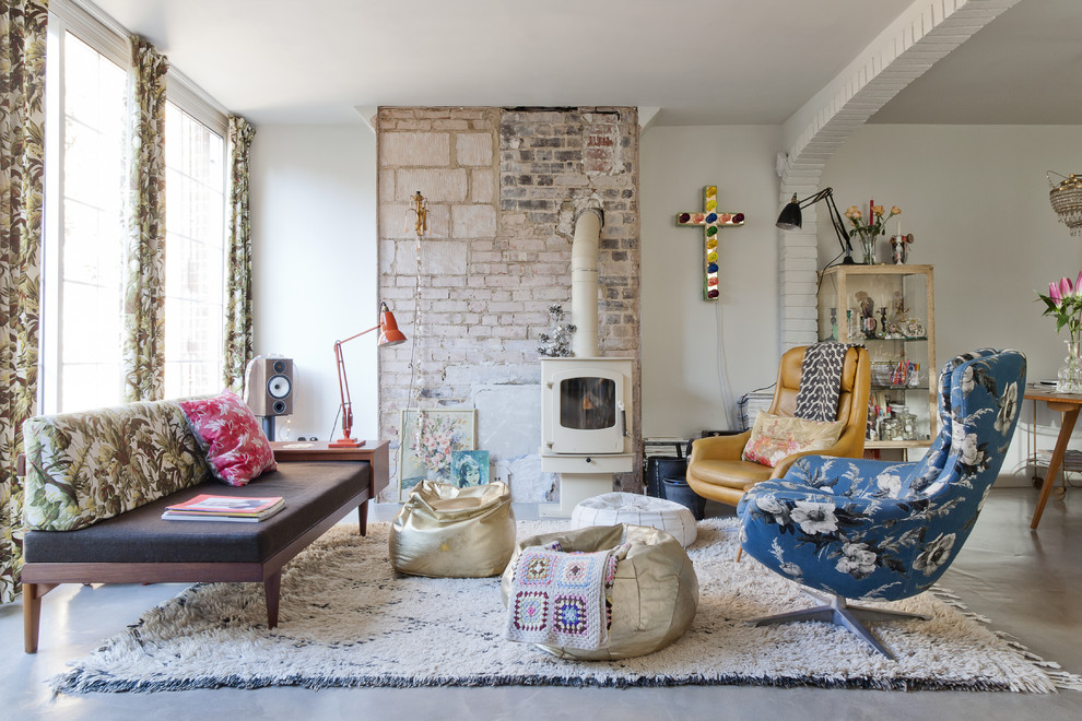 Photo of a large eclectic formal enclosed living room in Barcelona with white walls, concrete flooring, a wood burning stove and no tv.