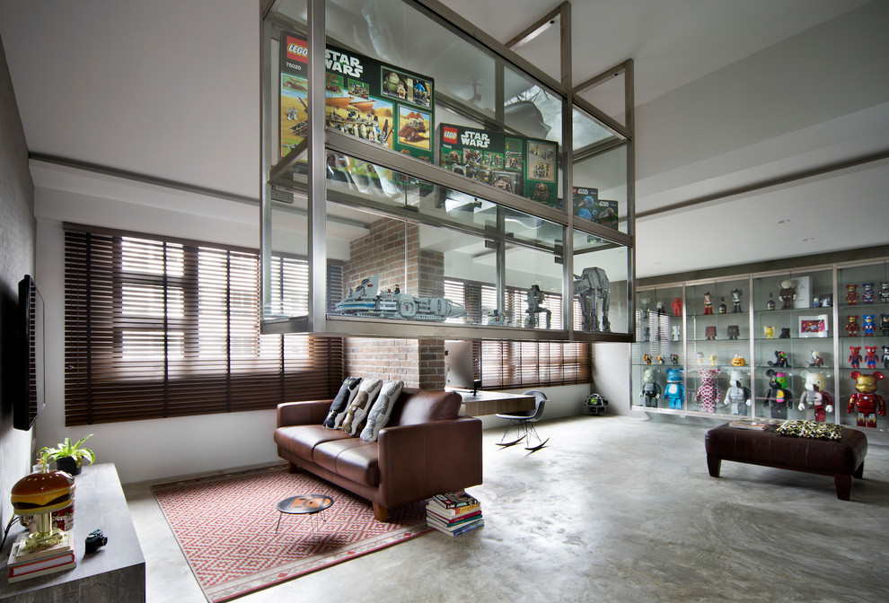 Photo of a large industrial open plan living room in Singapore with grey walls and concrete flooring.