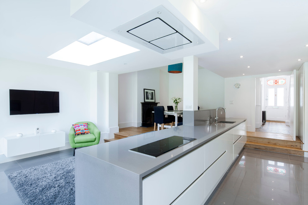 Kleines, Offenes Modernes Wohnzimmer mit weißer Wandfarbe, Keramikboden und TV-Wand in Sonstige