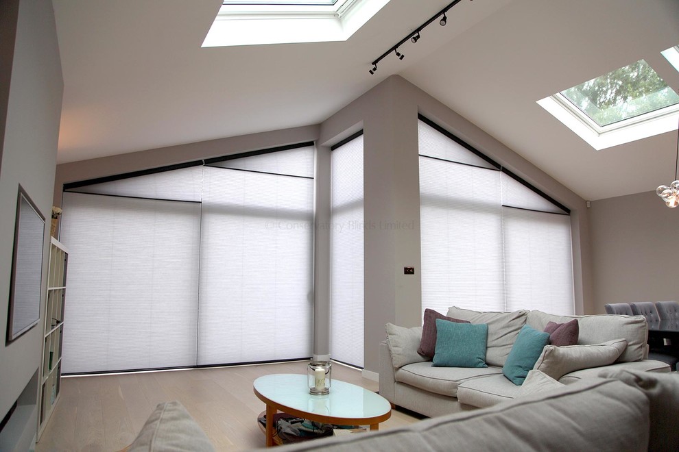 Großes, Repräsentatives, Fernseherloses Modernes Wohnzimmer ohne Kamin mit beiger Wandfarbe, hellem Holzboden und beigem Boden in Surrey