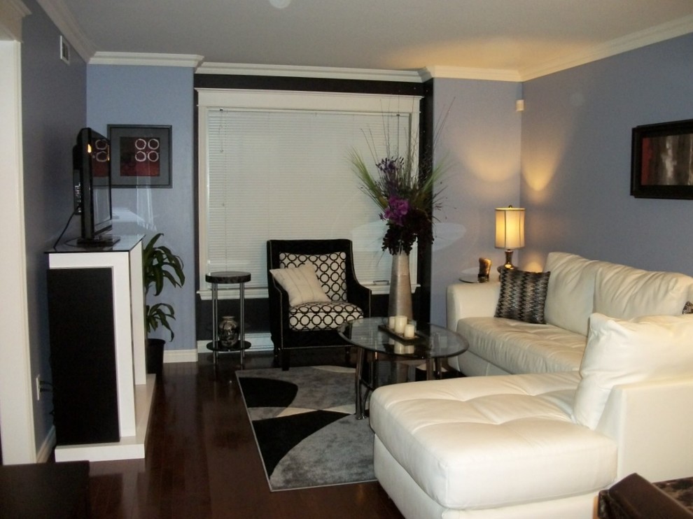 Стильный дизайн: открытая гостиная комната среднего размера в современном стиле с фиолетовыми стенами, паркетным полом среднего тона, стандартным камином, отдельно стоящим телевизором и коричневым полом - последний тренд