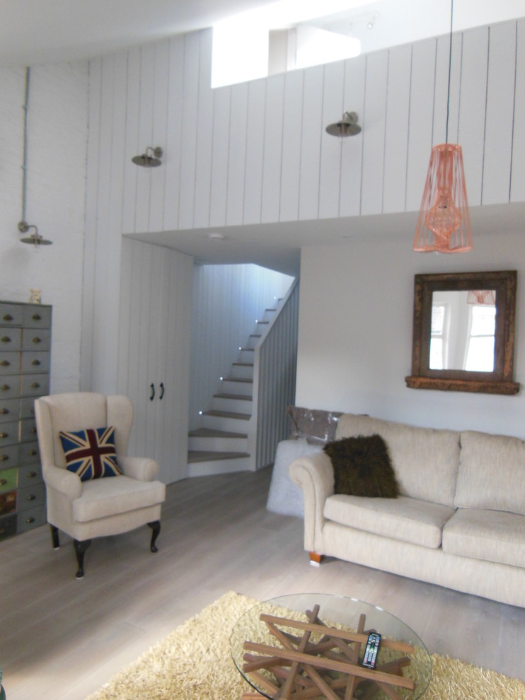 Mittelgroßes, Offenes Skandinavisches Wohnzimmer mit weißer Wandfarbe, hellem Holzboden und Kaminumrandung aus Backstein in London