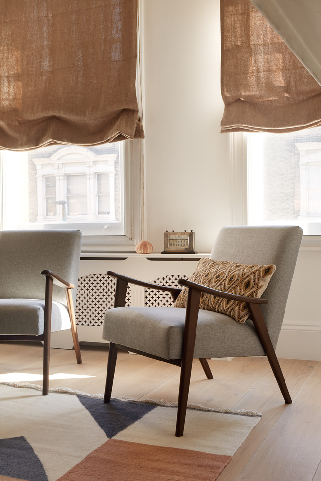 Design ideas for a medium sized scandi open plan living room in London with white walls, light hardwood flooring, a standard fireplace, a plastered fireplace surround, a wall mounted tv and grey floors.