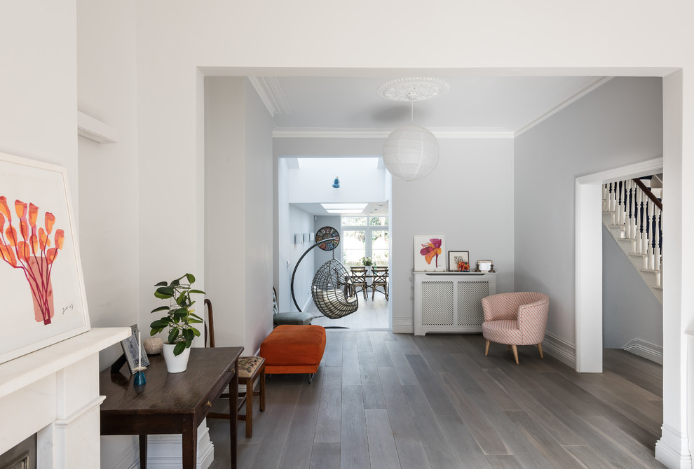 Cette image montre un salon minimaliste de taille moyenne et fermé avec un mur gris et parquet clair.