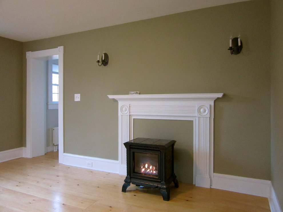 Mid-sized elegant formal and enclosed light wood floor living room photo in Boston with green walls, a wood stove and a wood fireplace surround