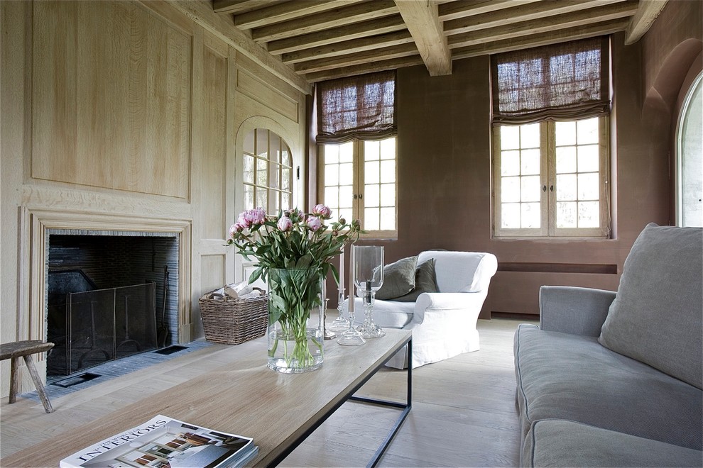 Пример оригинального дизайна: гостиная комната в стиле кантри с коричневыми стенами, стандартным камином и фасадом камина из дерева