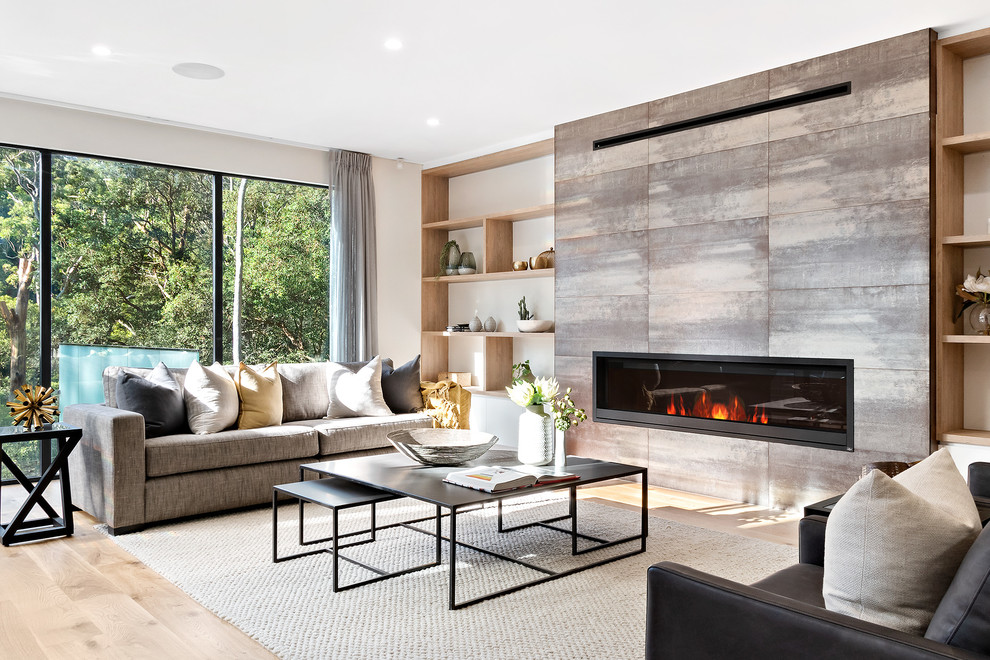 Offenes Modernes Wohnzimmer mit weißer Wandfarbe, hellem Holzboden, Gaskamin, gefliester Kaminumrandung und beigem Boden in Sydney