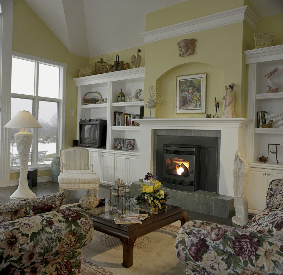 Mittelgroßes Klassisches Wohnzimmer mit gelber Wandfarbe, dunklem Holzboden, Kamin, gefliester Kaminumrandung, Multimediawand und braunem Boden in Washington, D.C.