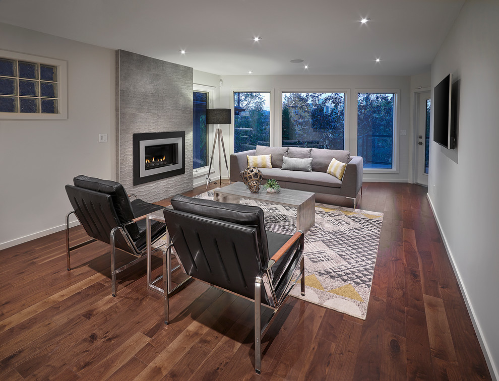 Inspiration for a large contemporary open concept medium tone wood floor living room remodel in Edmonton with a bar, white walls, a standard fireplace, a tile fireplace and a wall-mounted tv
