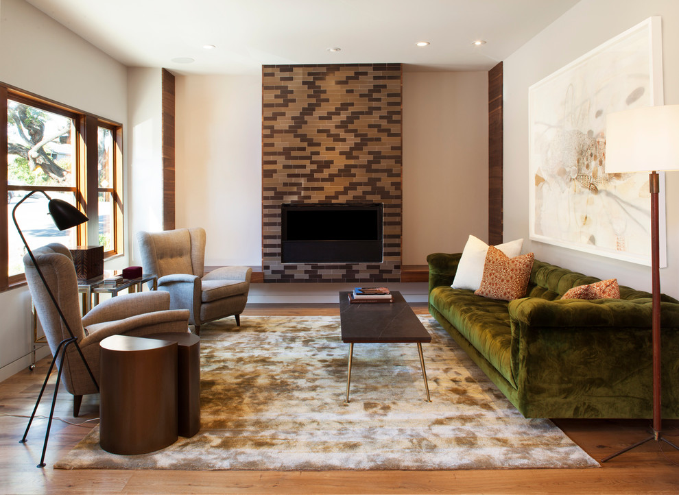 Imagen de salón actual con suelo de madera en tonos medios, todas las chimeneas, marco de chimenea de baldosas y/o azulejos y alfombra