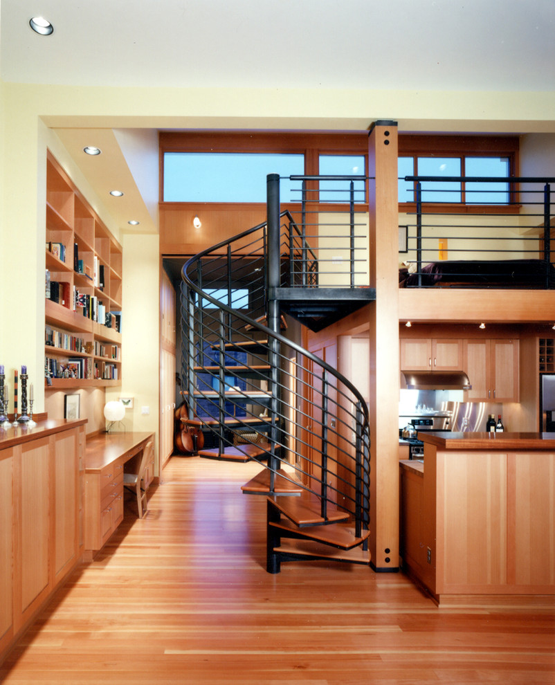 На фото: гостиная комната в стиле модернизм с с книжными шкафами и полками и желтыми стенами с