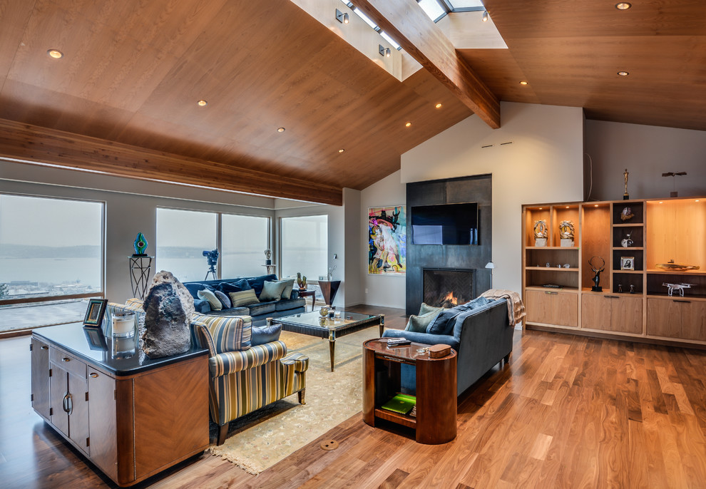 Inspiration for a large modern medium tone wood floor living room remodel in Seattle with beige walls, a standard fireplace and a wall-mounted tv