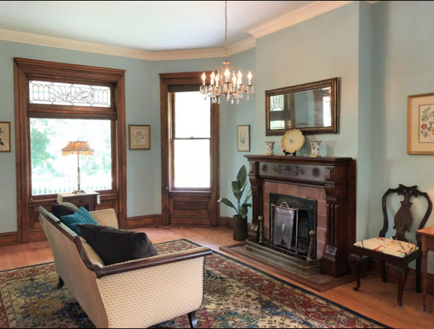 Inspiration för ett mycket stort vintage separat vardagsrum, med ett finrum, blå väggar, mellanmörkt trägolv, en standard öppen spis, en spiselkrans i trä och brunt golv