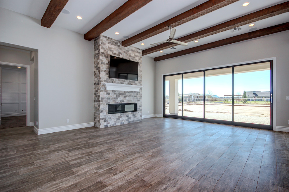 Living room - large transitional open concept ceramic tile and brown floor living room idea in Phoenix with gray walls, a standard fireplace, a tile fireplace and a wall-mounted tv