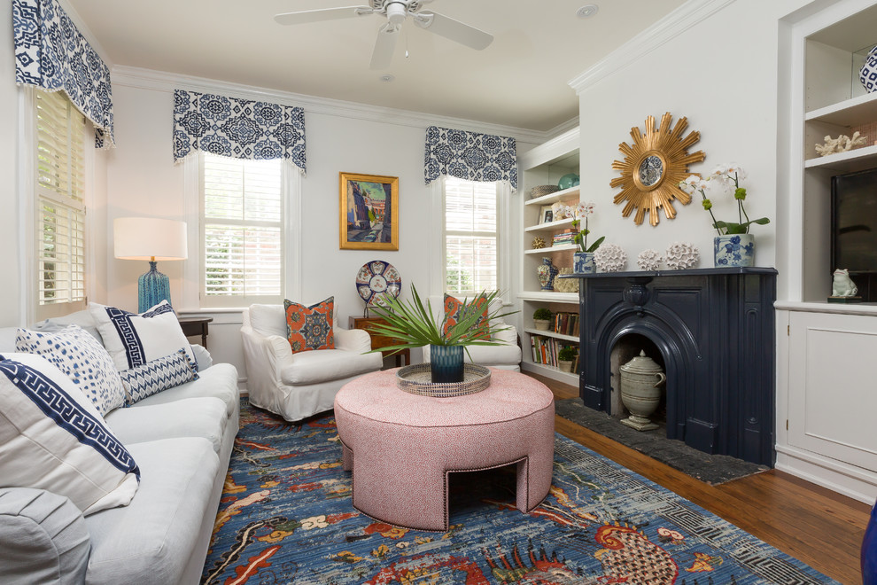 Inspiration for a traditional living room in Charleston with white walls, dark hardwood flooring and a standard fireplace.