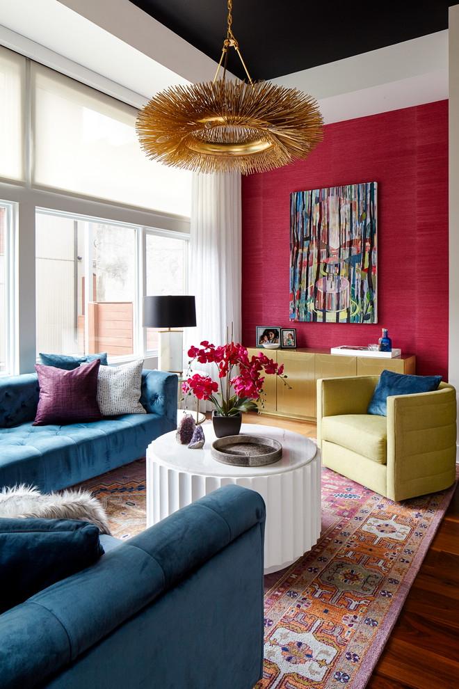 Cette photo montre un salon tendance de taille moyenne avec aucune cheminée, un sol marron, un mur rouge et parquet foncé.