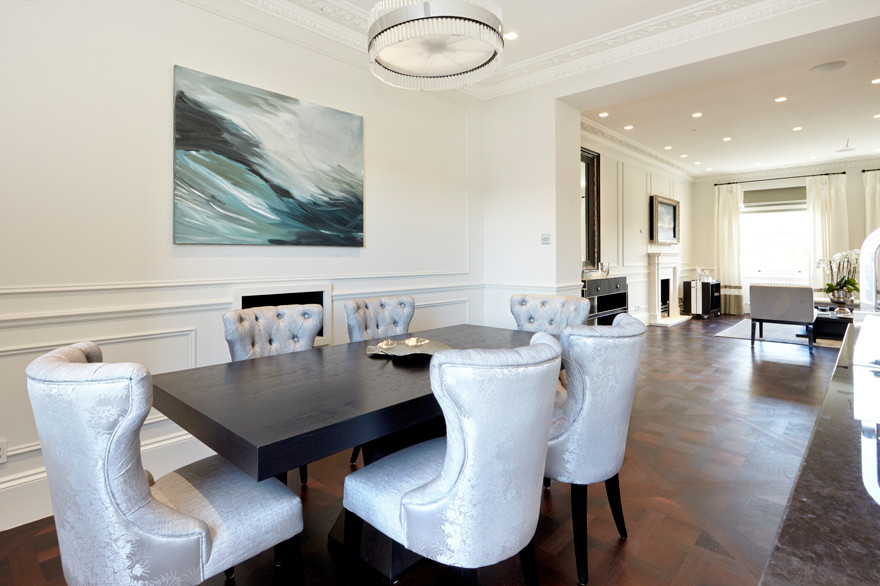 Aménagement d'une salle à manger classique de taille moyenne avec un mur blanc, parquet foncé et un manteau de cheminée en plâtre.