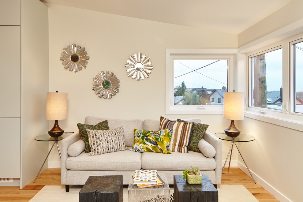 Cette image montre un petit salon minimaliste ouvert avec un mur beige, parquet clair et une cheminée d'angle.