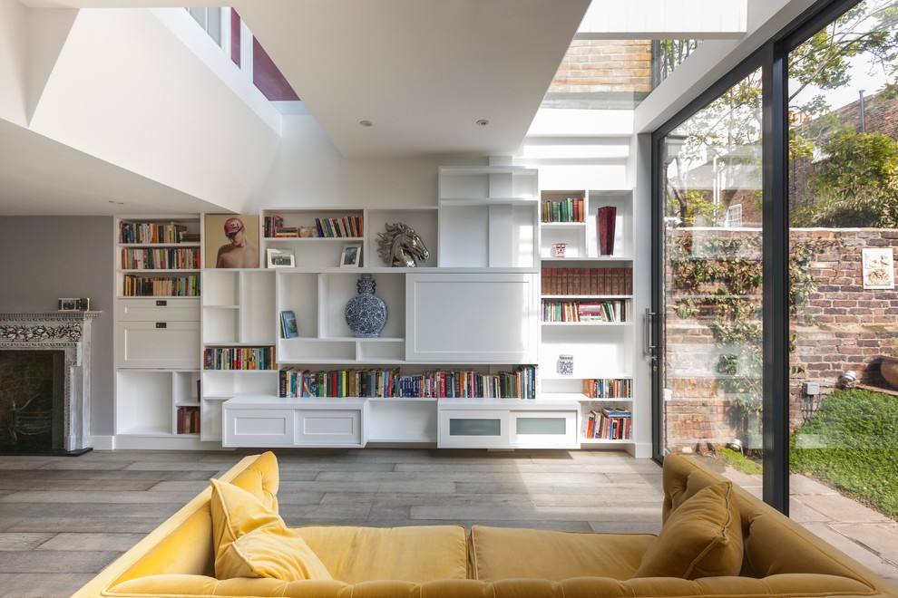 Example of a large danish formal and open concept light wood floor living room design in London with white walls, a concealed tv, a standard fireplace and a stone fireplace