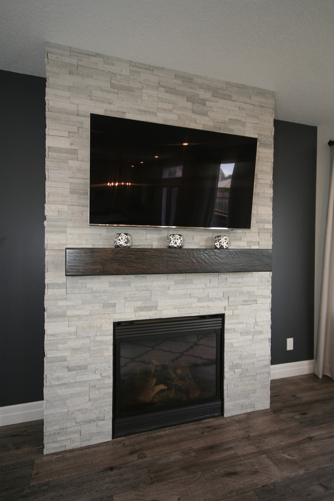 Mittelgroßes, Offenes Modernes Wohnzimmer mit grauer Wandfarbe, Vinylboden, Kamin, Kaminumrandung aus Stein und TV-Wand