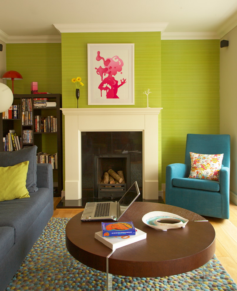 Cette photo montre un salon éclectique de taille moyenne et fermé avec un mur vert, un sol en bois brun et une cheminée standard.