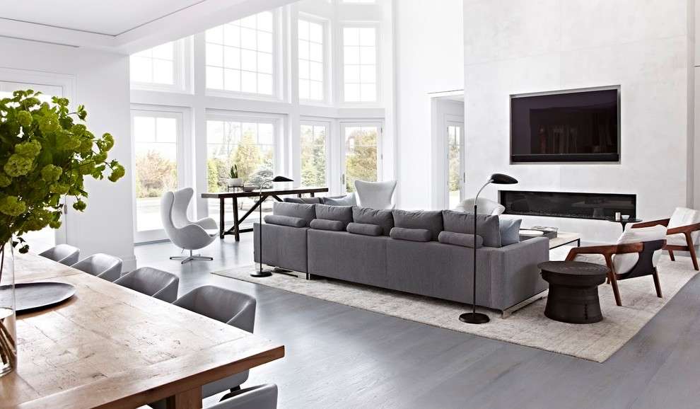 Cette photo montre un grand salon tendance ouvert avec un mur blanc, sol en béton ciré, une cheminée ribbon, un téléviseur fixé au mur et un sol gris.