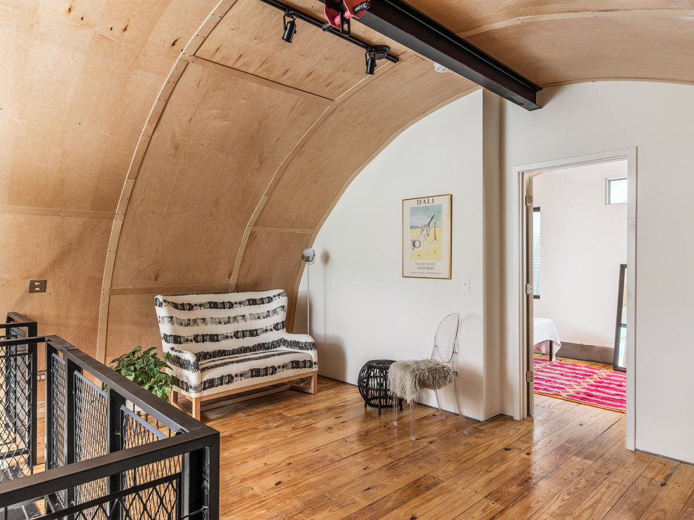 Diseño de salón tipo loft industrial pequeño con suelo de madera clara