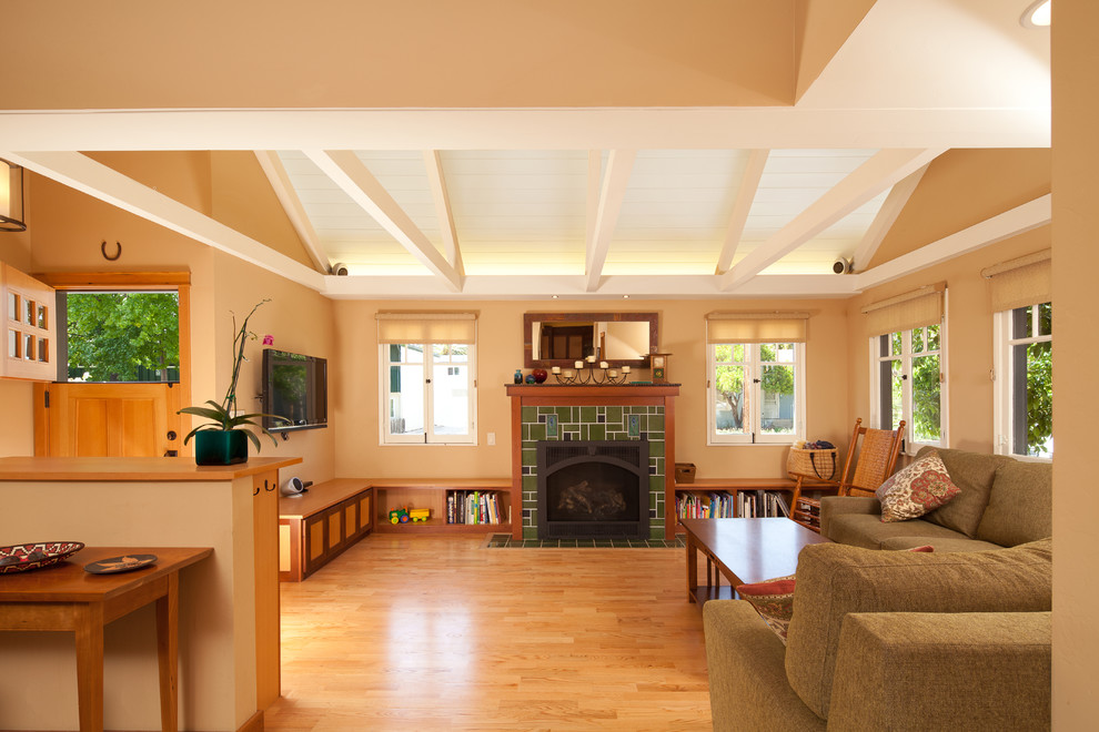 Large arts and crafts open concept light wood floor and brown floor living room library photo in San Luis Obispo with beige walls, a standard fireplace, a tile fireplace and a wall-mounted tv