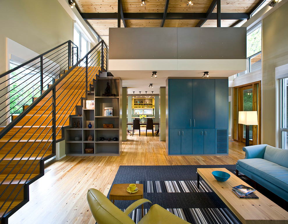 Diseño de salón abierto actual de tamaño medio sin televisor y chimenea con paredes verdes, suelo de madera clara y suelo beige