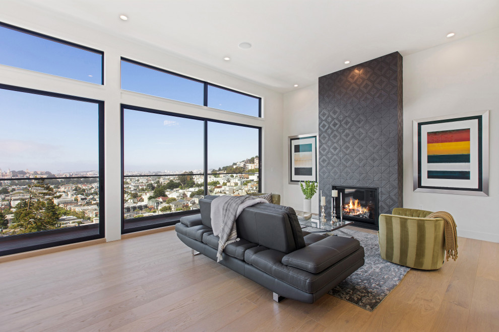Mittelgroßes, Fernseherloses, Offenes Modernes Wohnzimmer mit weißer Wandfarbe, gefliester Kaminumrandung, braunem Holzboden, Kamin und braunem Boden in San Francisco