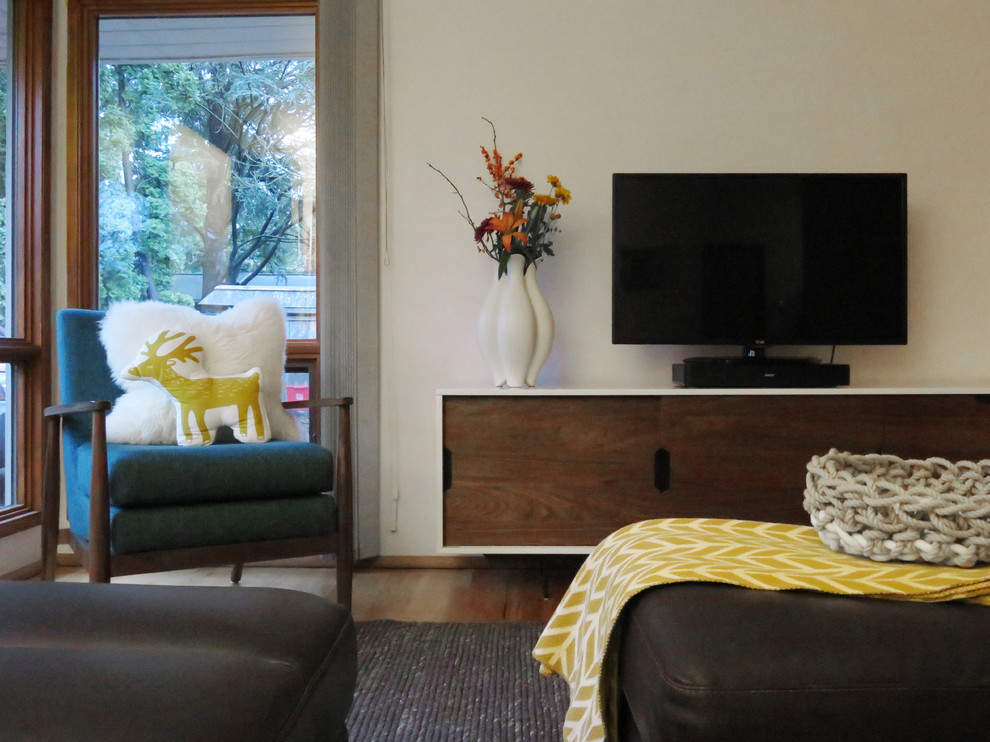 Ejemplo de salón cerrado moderno pequeño con paredes blancas, suelo de madera clara, chimenea de doble cara, marco de chimenea de ladrillo y televisor independiente