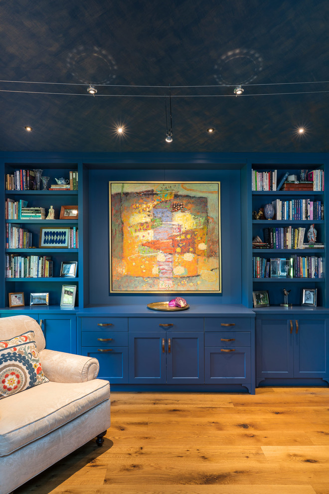 На фото: изолированная гостиная комната среднего размера в стиле неоклассика (современная классика) с с книжными шкафами и полками, синими стенами, паркетным полом среднего тона и оранжевым полом без телевизора с