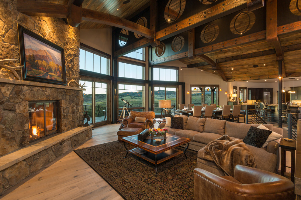 Rustic open plan living room in Denver with beige walls, medium hardwood flooring, a corner fireplace and a stone fireplace surround.