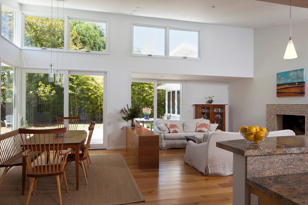 Стильный дизайн: гостиная комната в современном стиле с белыми стенами и стандартным камином - последний тренд
