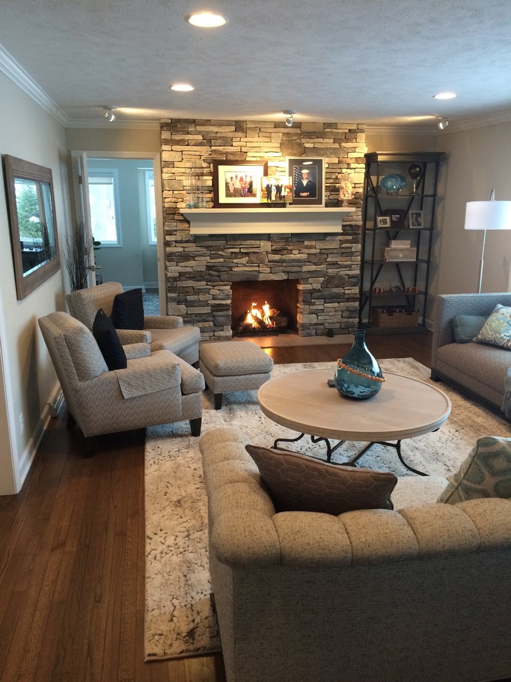 Inspiration for a mid-sized transitional open concept dark wood floor and brown floor living room remodel in Grand Rapids with gray walls, a standard fireplace and a stone fireplace