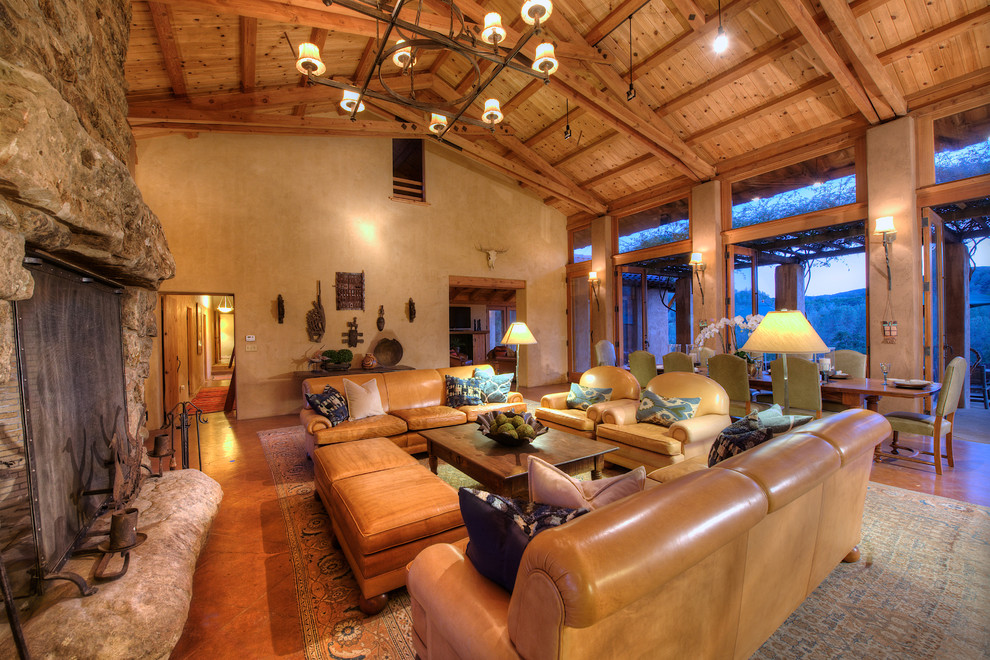Idées déco pour un très grand salon sud-ouest américain ouvert avec une salle de réception, un mur beige, un sol en bois brun, une cheminée standard et un manteau de cheminée en pierre.